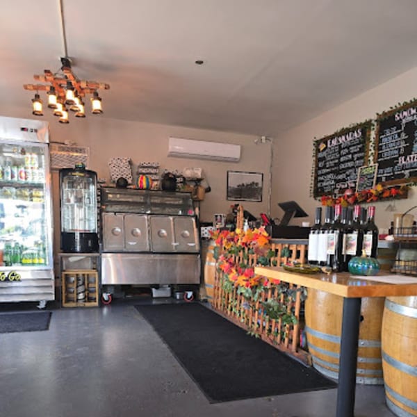 Interior of Lord Empanada, featuring a counter with wine bottles, menu boards, and empanada warmers.